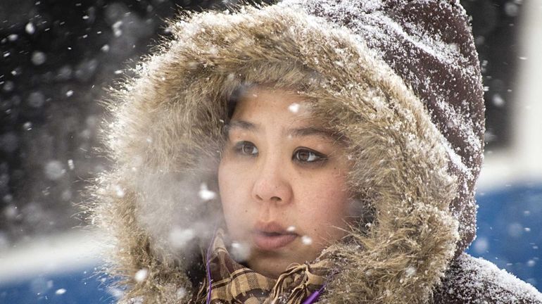 Valley Stream resident Suni Kim endures the frigid weather while...