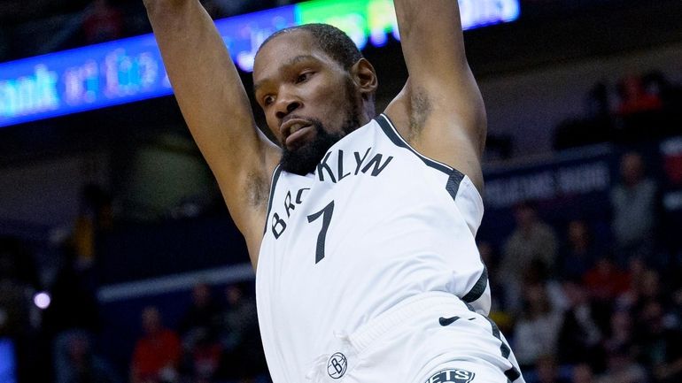 Nets forward Kevin Durant dunks in the first half of...