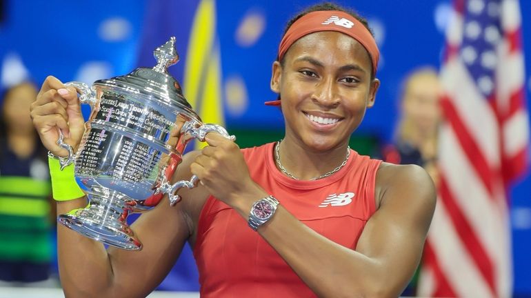 Coco Gauff poses with the trophy after defeating Aryna Sabalenka to...