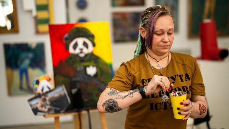 Ukrainian Anastasiya Sereda paints a canvas in an art class...