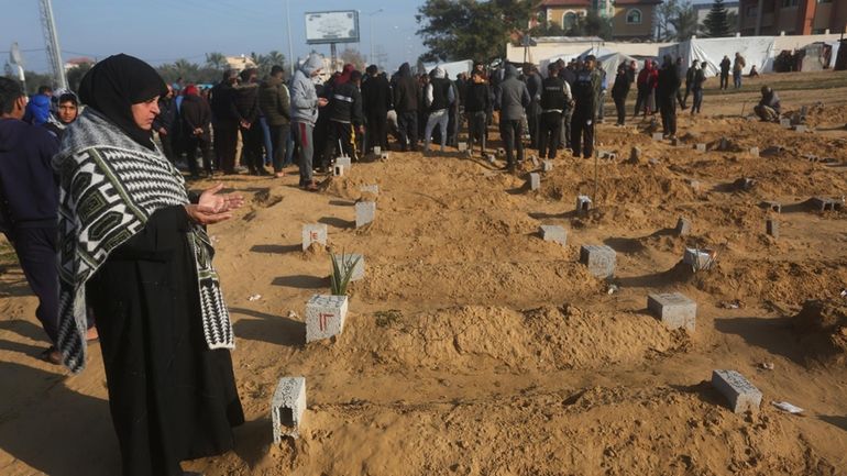 A Palestinian woman prays for a relative killed in the...