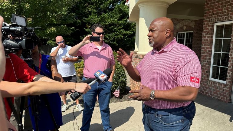 North Carolina Republican gubernatorial candidate Mark Robinson, right, speaks with...