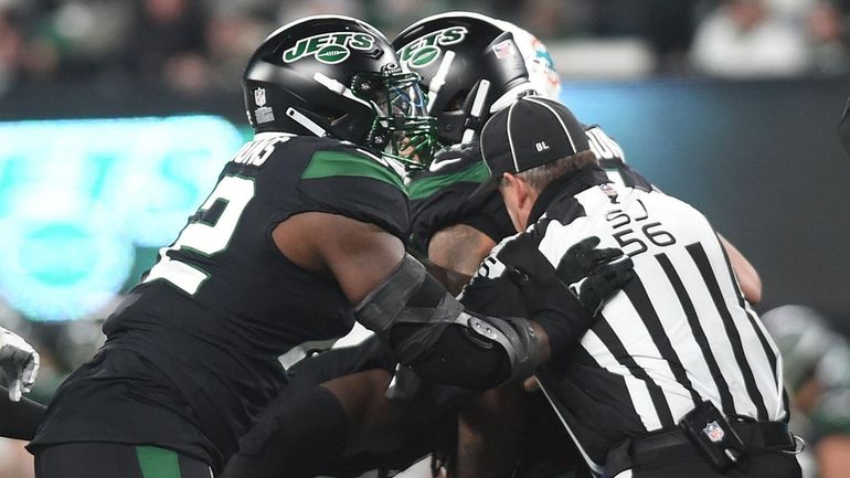 Michael Clemons #72, New York Jets defensive lineman, left, makes...