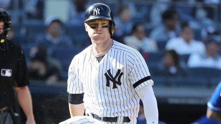 Yankees left fielder Clint Frazier reacts by breaking his bat...