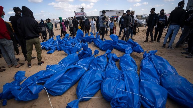 Palestinians bury the bodies of people who were killed in...