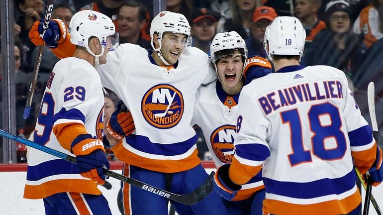 The Islanders' Mathew Barzal (13) celebrates with Anthony Beauvillier (18),...