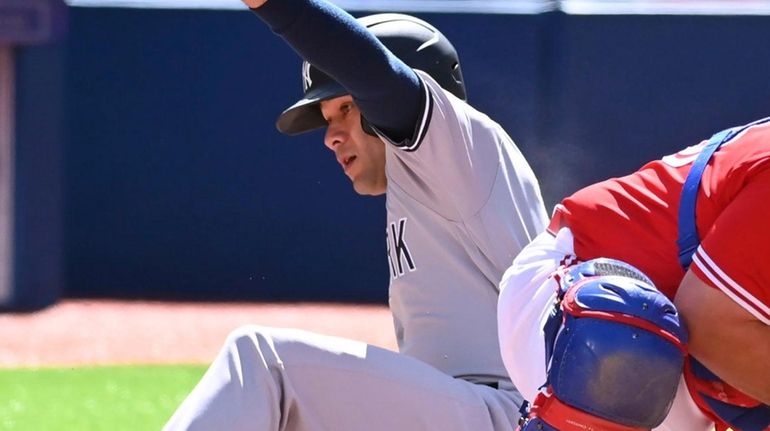 The Yankees' Isiah Kiner-Falefa, left, slides safely into home ahead...