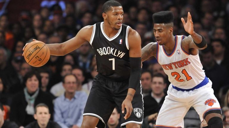 Joe Johnson of the Nets drives on Iman Shumpert of...