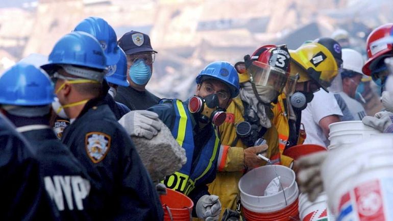 Rescue workers remove debris as they search for survivors at...