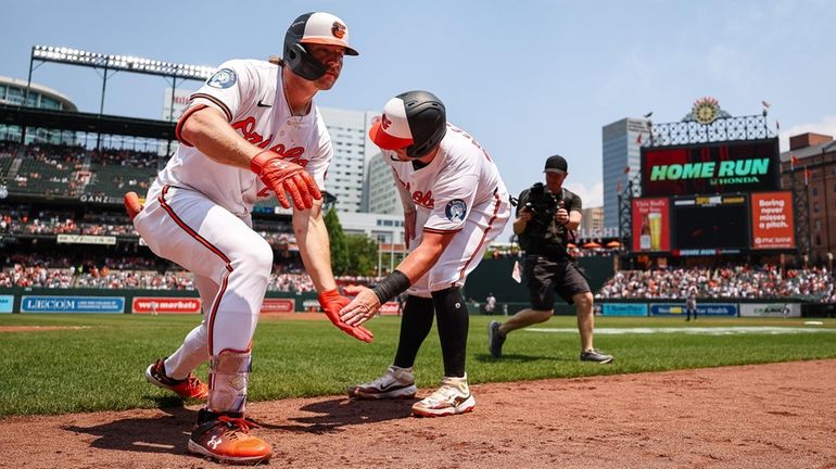 Gunnar Henderson of the Baltimore Orioles celebrates with James McCann after...