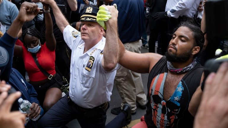 NYPD Chief of Department Terence Monahan takes a knee Monday...