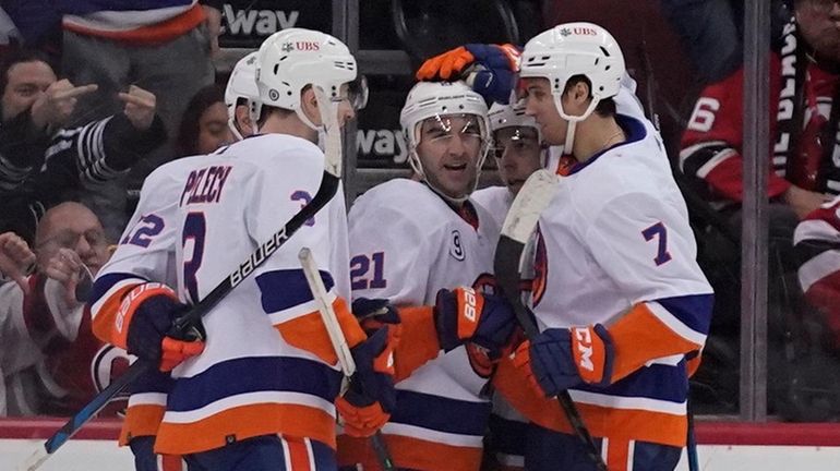 New York Islanders' Kyle Palmieri, center, celebrates his goal with...