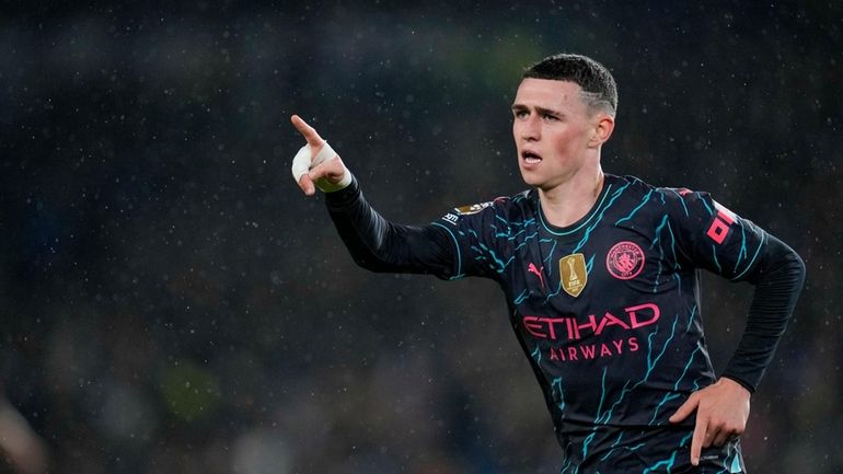 Manchester City's Phil Foden celebrates after scoring his side's third...