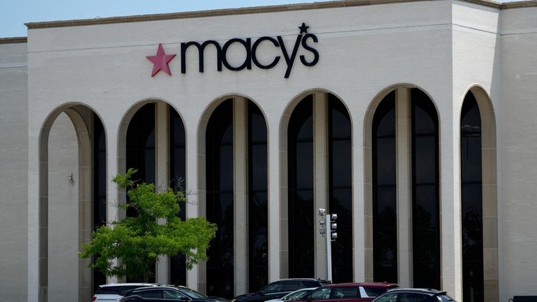 Cars are parked in front of a Macy's store at...