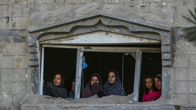 Palestinians look at the destruction after an Israeli airstrike on...