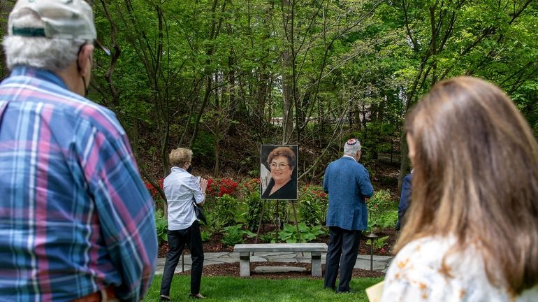 Members of the congregation view the garden dedication for Annie...