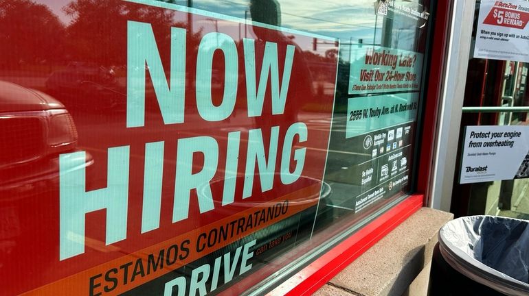 A hiring sign is displayed at a retail store in...