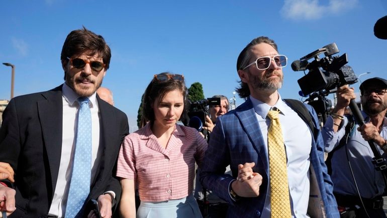 Amanda Knox arrives flanked by her husband Christopher Robinson, right,...