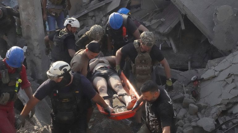 Rescuers carry a wounded man after Russian missile attack on...