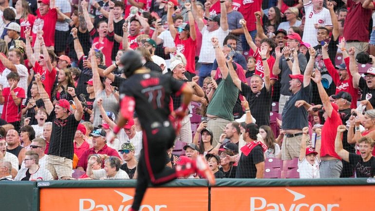 Cincinnati Reds fans cheer as Reds' Rece Hinds (77) rounds...