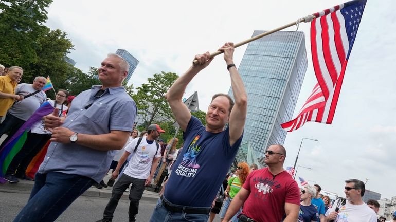 U.S. Ambassador Mark Brzezinski holds a U.S. flag as he...