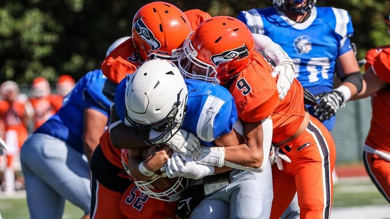 New Hyde Park quarterback Aiden Garvey is swallowed up by...