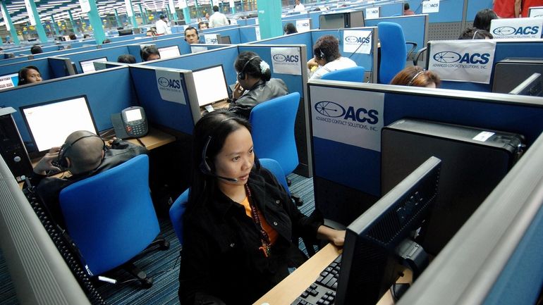 Filipino call center agents attend to U.S. clients from a...
