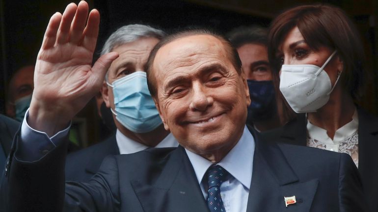 Former Italian Premier Silvio Berlusconi waves to reporters as he...