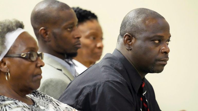 Eddie Terrell Parker, right, and Michael Corey Jenkins, center, listen...