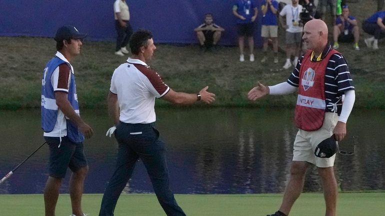 Europe's Rory Mcilroy, centre, goes to shake hands with United...