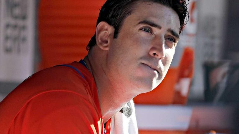 Mets starting pitcher Matt Harvey sits in the dugout staring...
