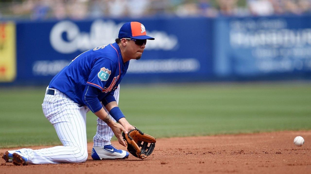 New York Mets' David Wright, center, slides into third base after