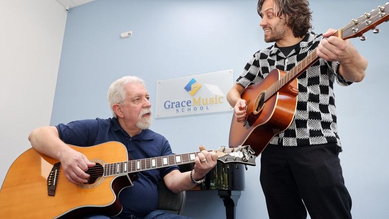 Mike Macaluso takes a guitar lesson with instructor Cameron Keym at...