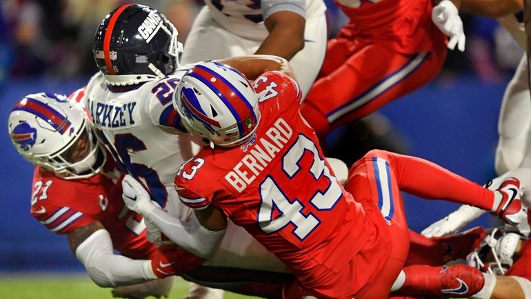 Bills linebacker Terrel Bernard and safety Jordan Poyer take down...