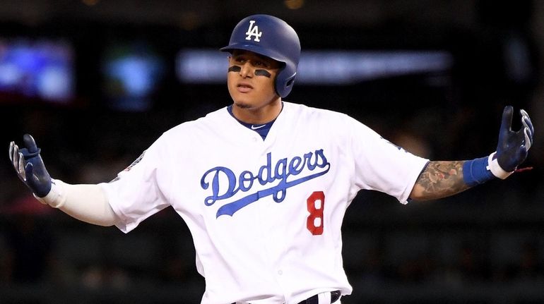 Manny Machado of the Dodgers reacts after hitting a double...