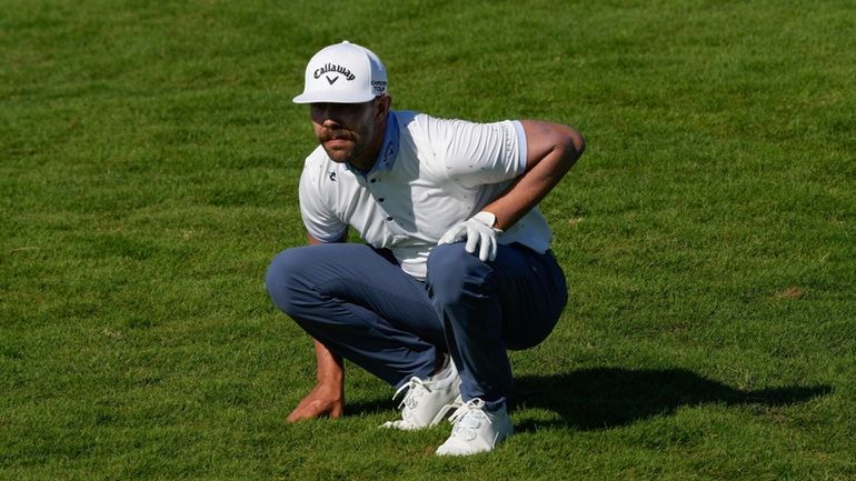 Erik van Rooyen, of South Africa, studies his third shot...