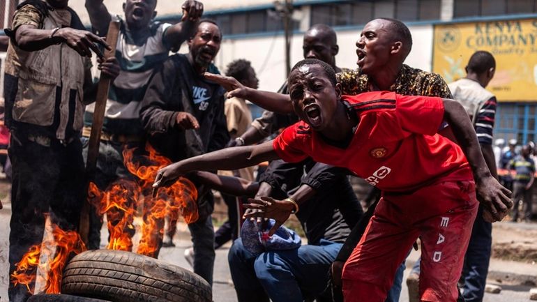 Protesters barricade the street with rocks and burning tires during...