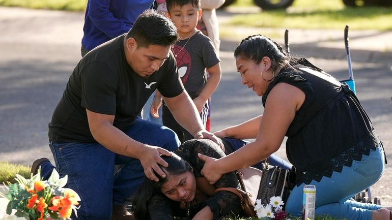 Domatilia Caal, center, is consoled by her brother, Cornelio, and...