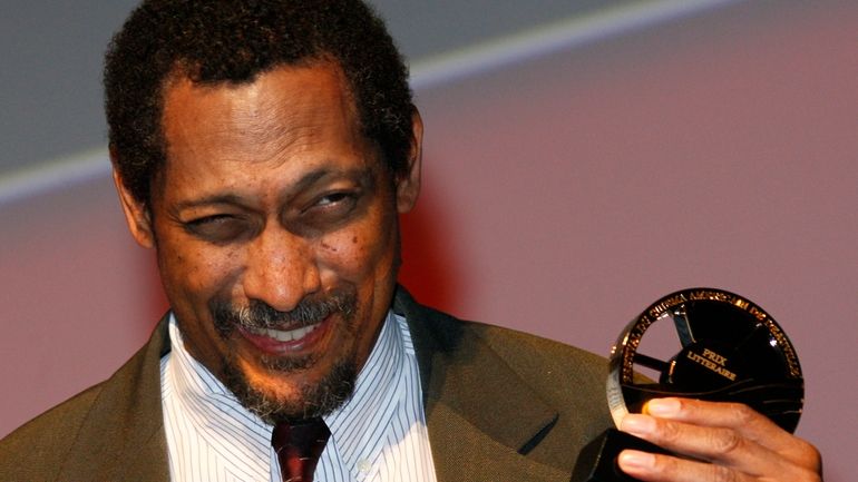 U.S. writer Percival Everett holds his trophy after he was...