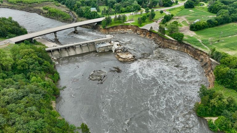 Floodwater continues to carve a channel around the Rapidan Dam,...