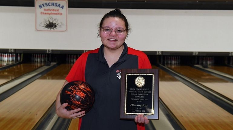 Alex Martinez of St. John the Baptist holds her trophy at the...