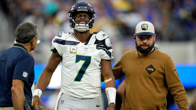 Seattle Seahawks quarterback Geno Smith (7) is helped off the...