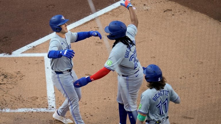 Toronto Blue Jays' Daulton Varsho, left, celebrates with teammates Vladimir...