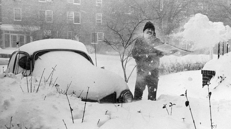 Greg Murphy tries to dig out out his snow-covered Volkswagen in...