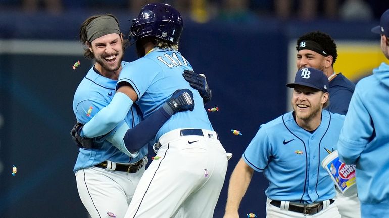 Tampa Bay Rays' Josh Lowe, left, hugs Junior Caminero as...