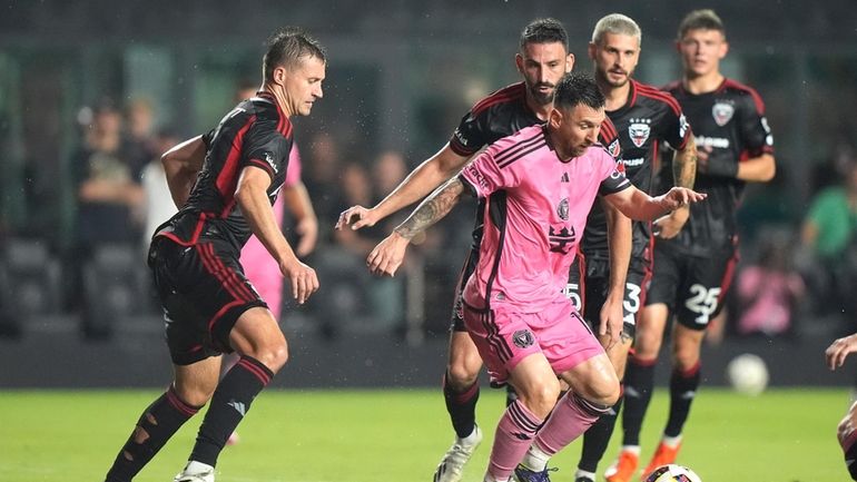 Inter Miami forward Lionel Messi, center, tries to control the...