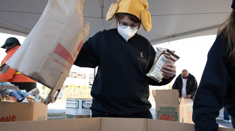 Melissa Vell, a volunteer, loads a bin Friday during a food...