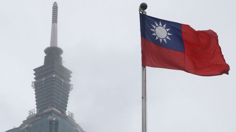 A Taiwan national flag flutters near the Taipei 101 building...