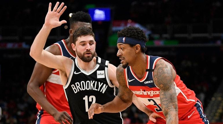 Washington Wizards guard Bradley Beal dribbles next to Nets forward...