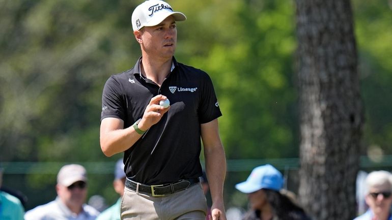 Justin Thomas reacts after making his putt on the fifth...